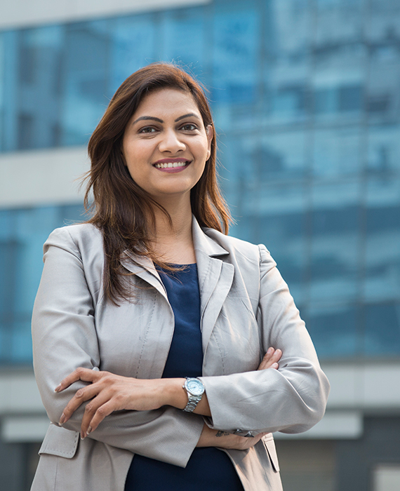 A woman business dressed woman smiling with her arms crossed